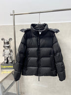 Long hooded puffer jacket, dark color, front view with stand collar and zipper pull