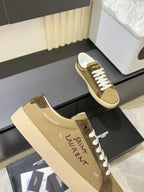 YSL unisex sneakers close-up, tan and brown uppers with white lace stitching