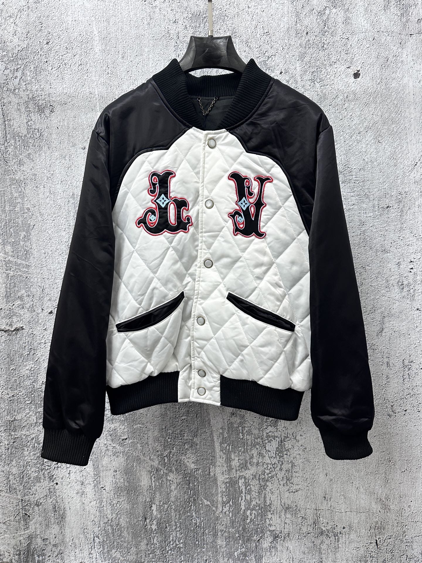 Quilted black-and-white jacket with button front and logo patches