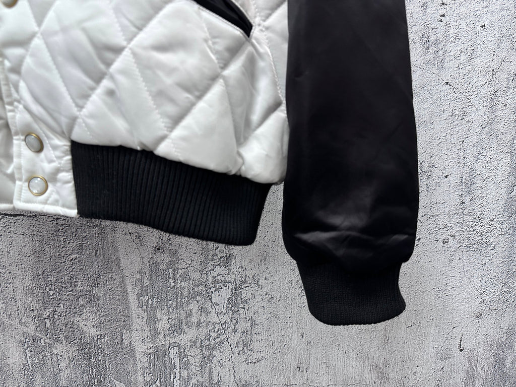 Quilted jacket hem with ribbed cuff and snap buttons on white panel