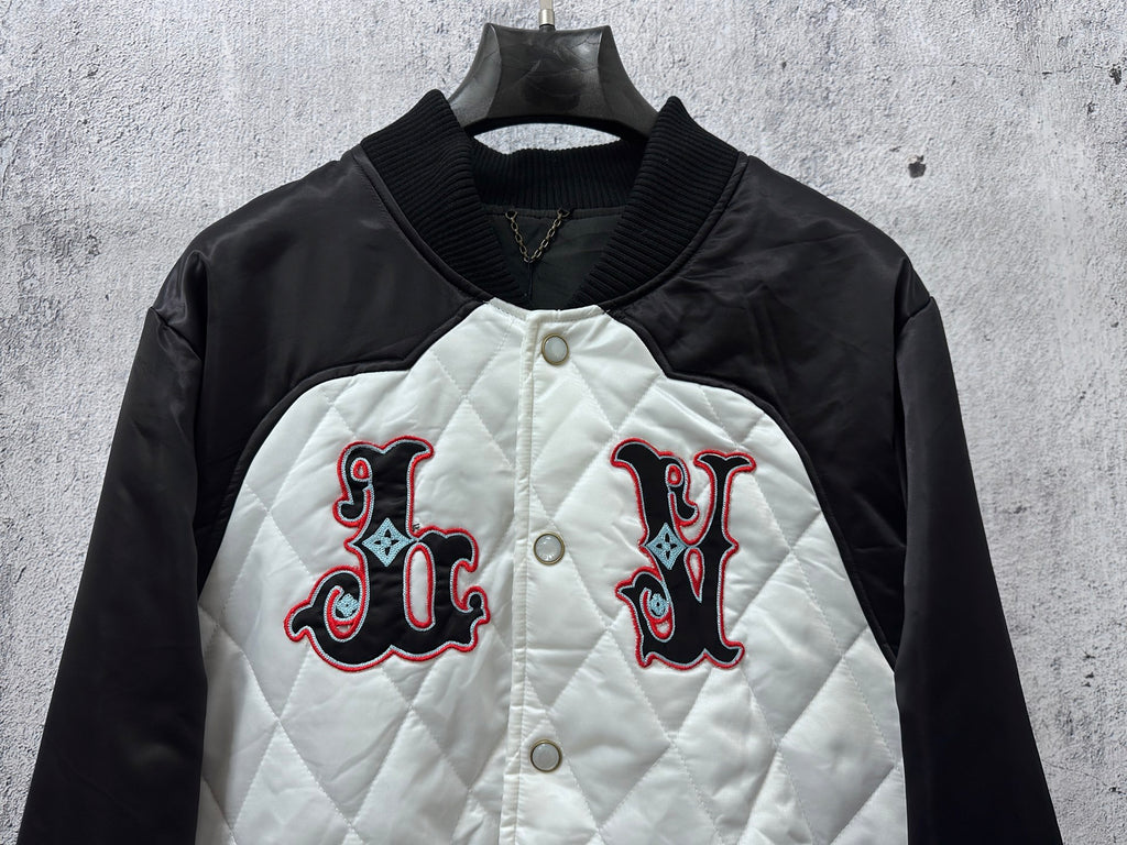 Black-and-white quilted jacket with embroidered red-and-black logo and snap buttons