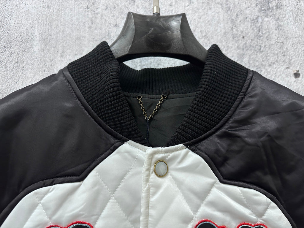 Quilted jacket with ribbed collar, snap buttons, and small gold chain detail