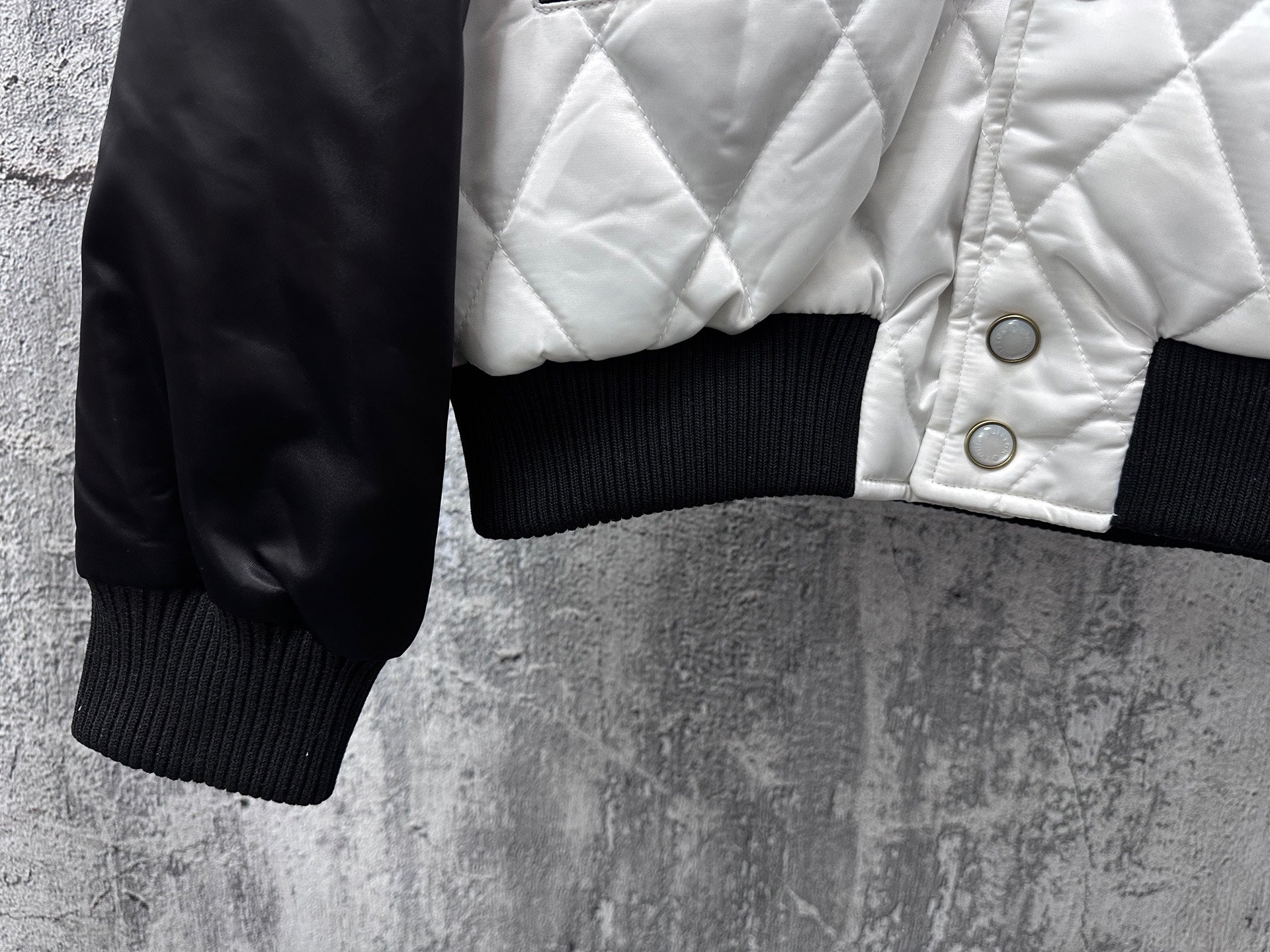 Quilted jacket sleeve with ribbed cuff and snap-detailed white front panel