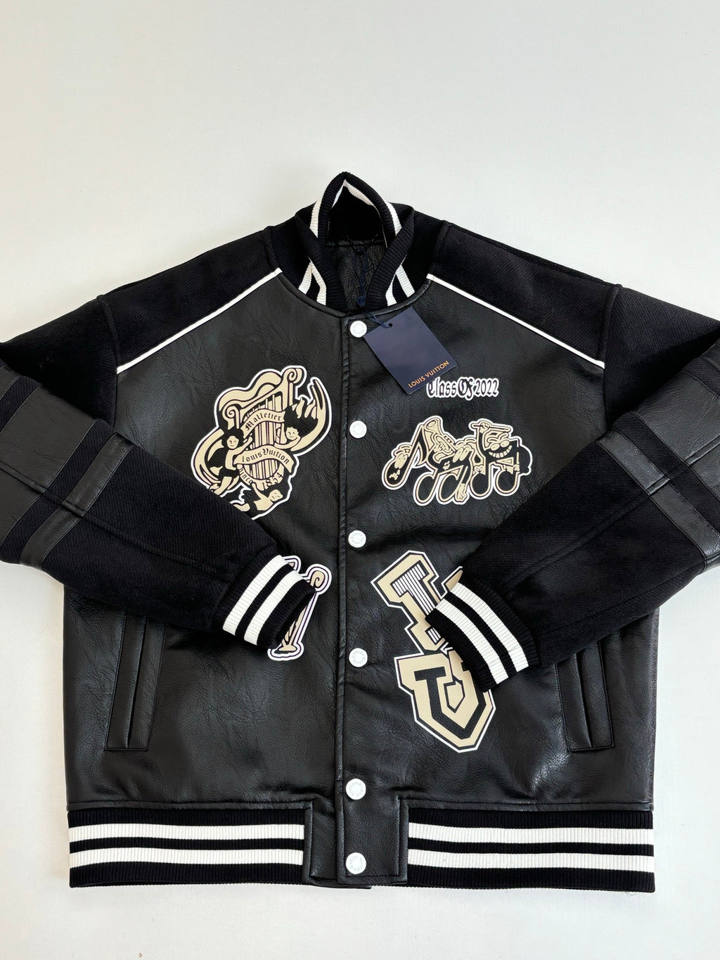 Louis Vuitton long jacket front view, black with cream crest patches and striped ribbing