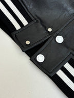 Louis Vuitton long jacket close-up, black fabric with snap placket and striped ribbed cuffs