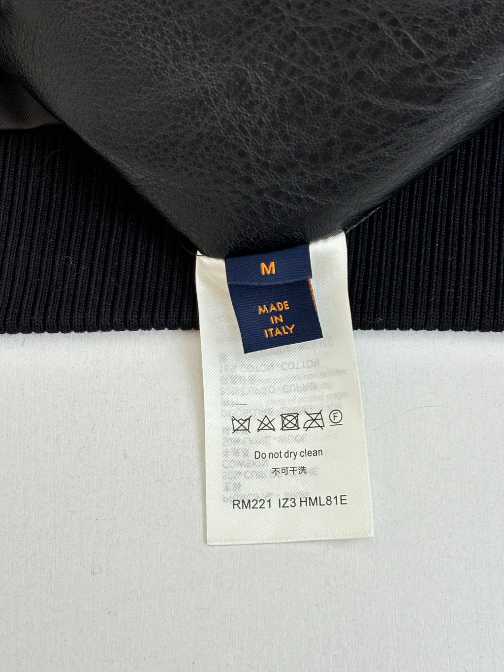 Size M tag on black knit garment, made in Italy, care label
