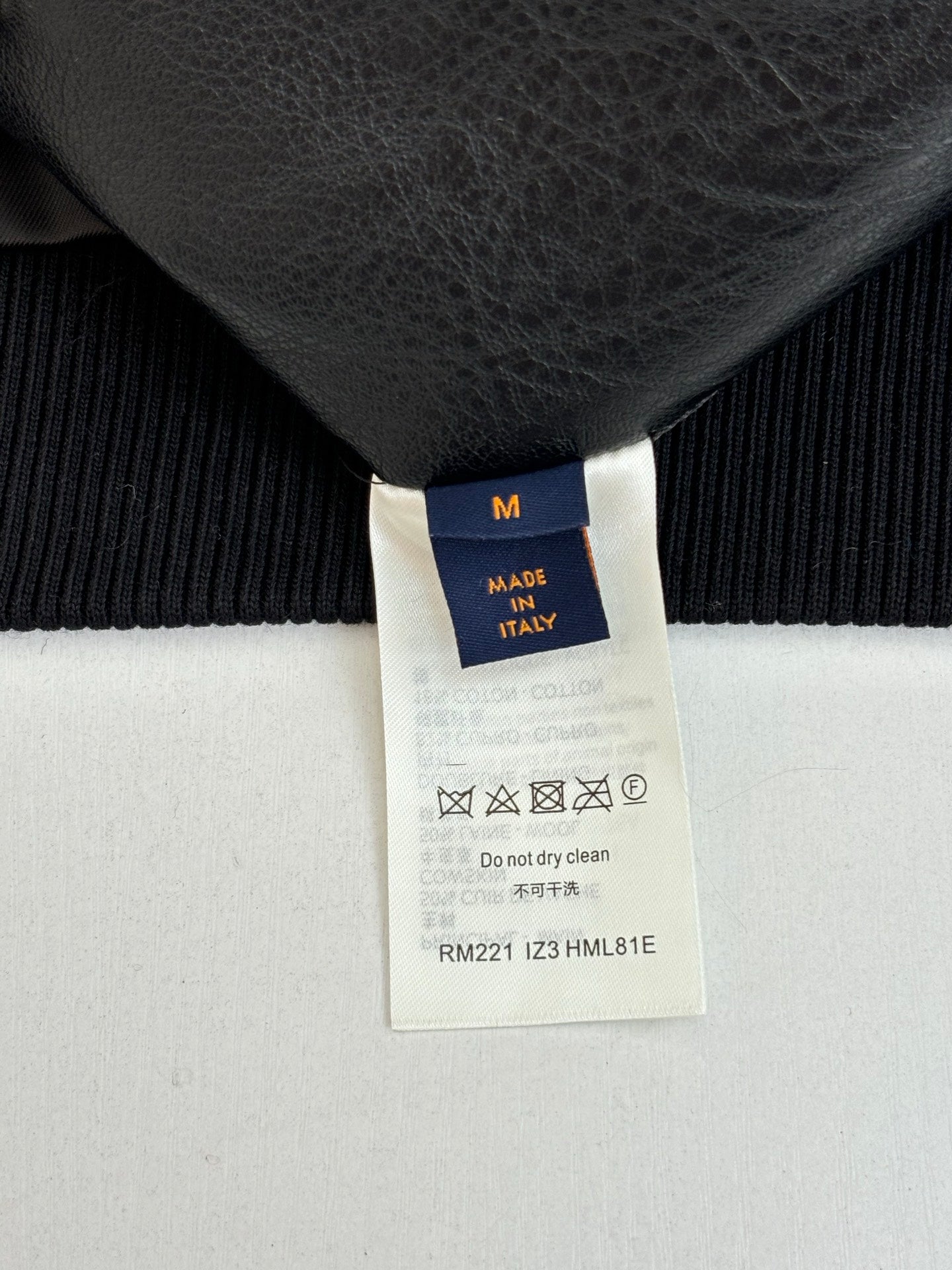 Size M tag on black knit garment, made in Italy, care label