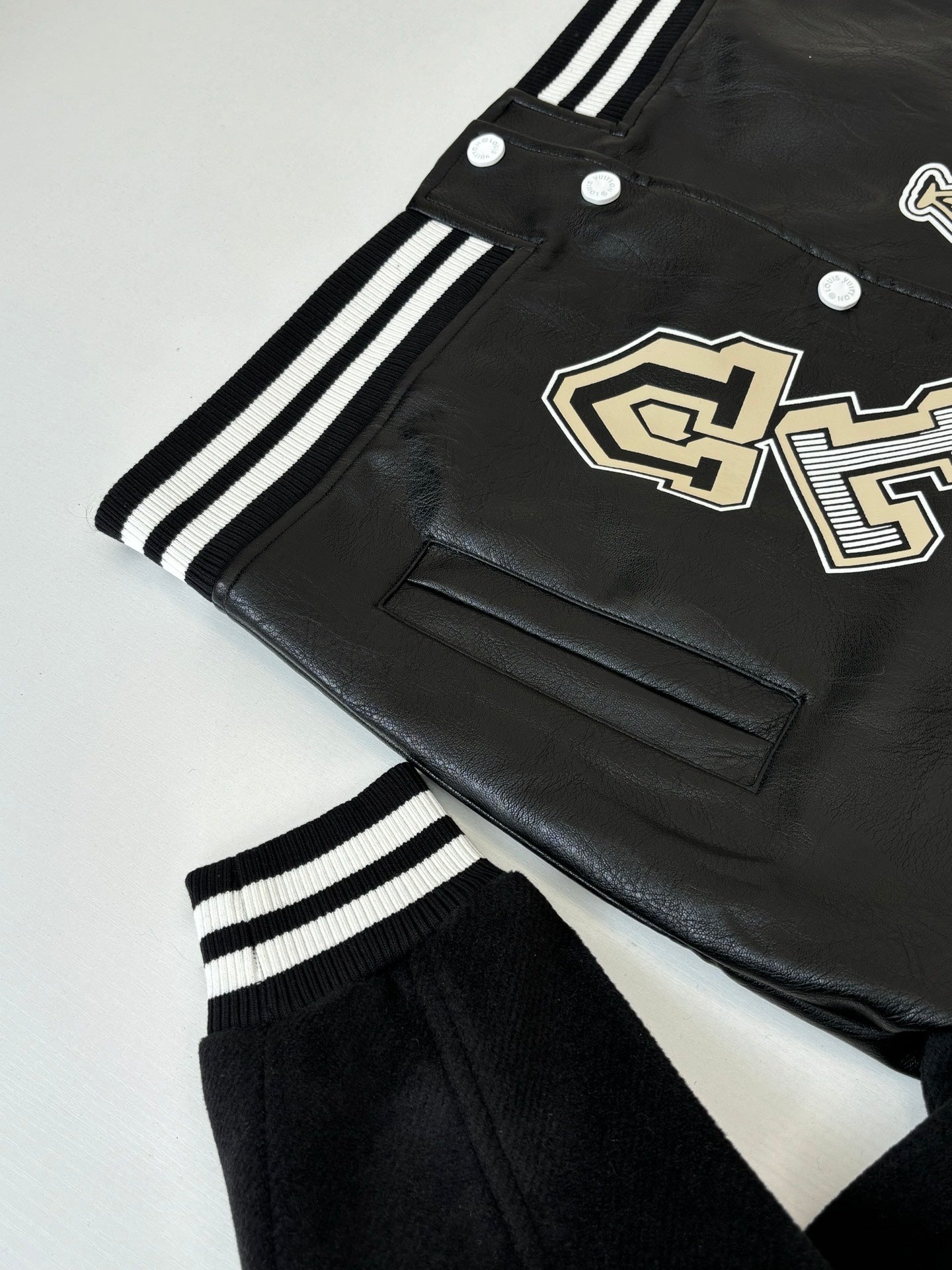 Louis Vuitton long jacket, black with cream logo patch, welt pocket and striped trim