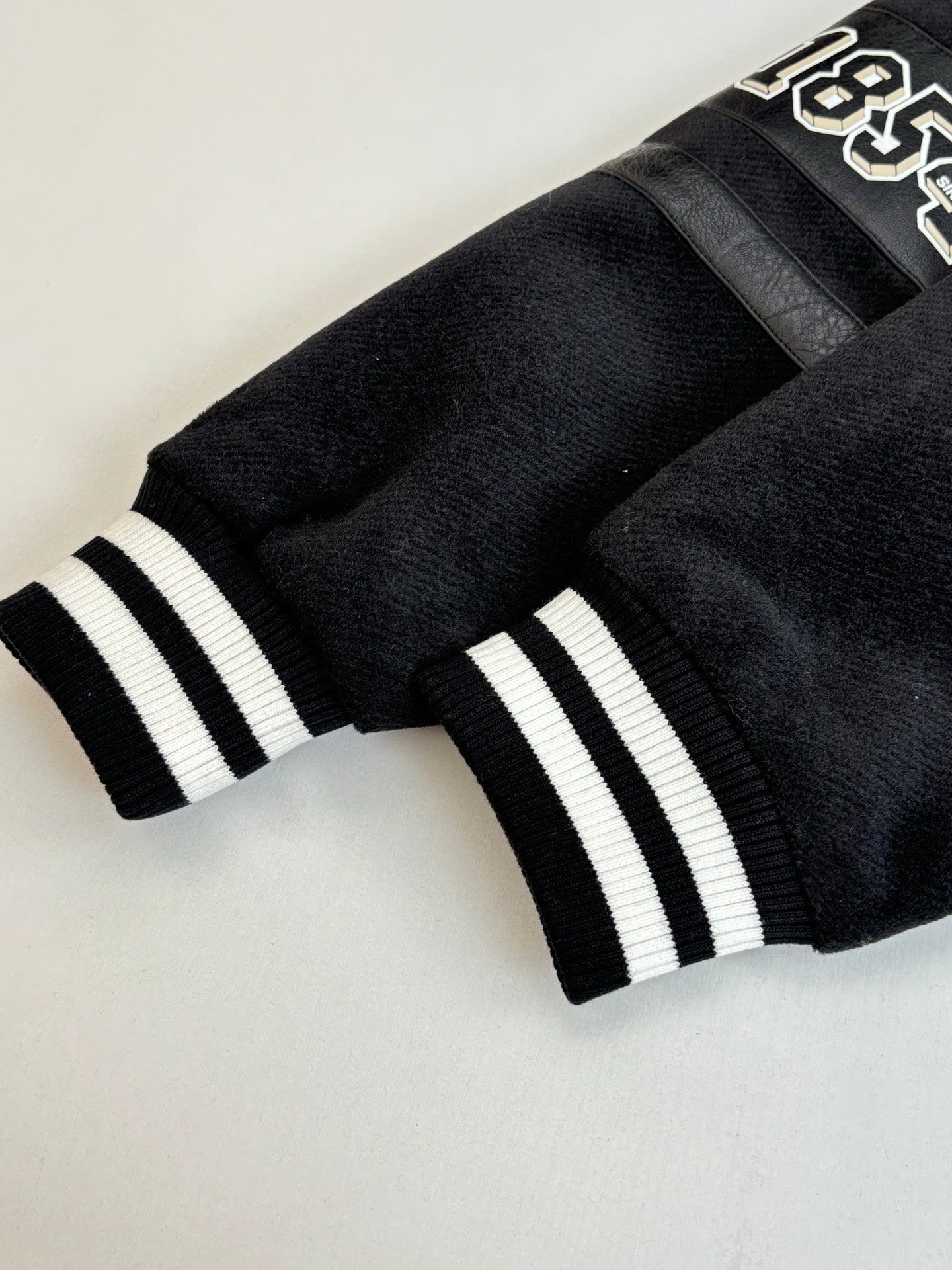 Black knit sweater with white striped cuffs and Louis Vuitton monogram band
