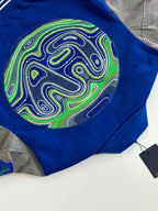 Blue varsity jacket patch detail with neon swirl artwork on front