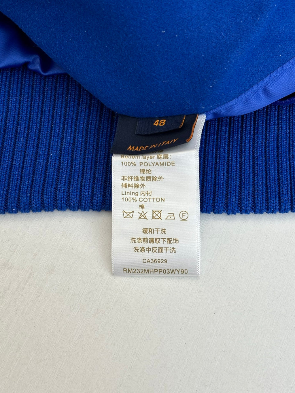 Size and fabric-content label on blue ribbed long-sleeve top