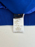 Size and fabric-content label on blue ribbed long-sleeve top