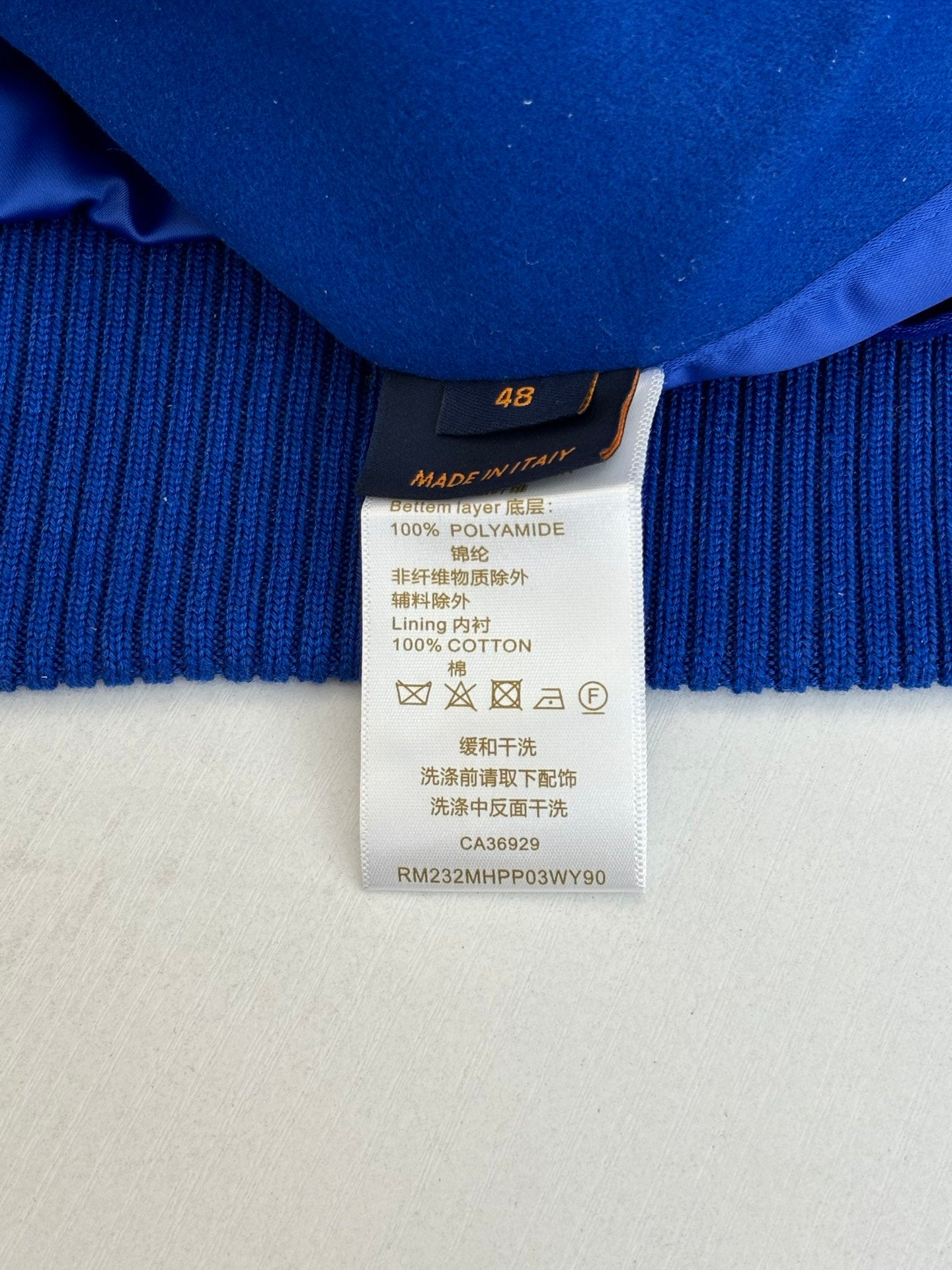 Size and fabric-content label on blue ribbed long-sleeve top