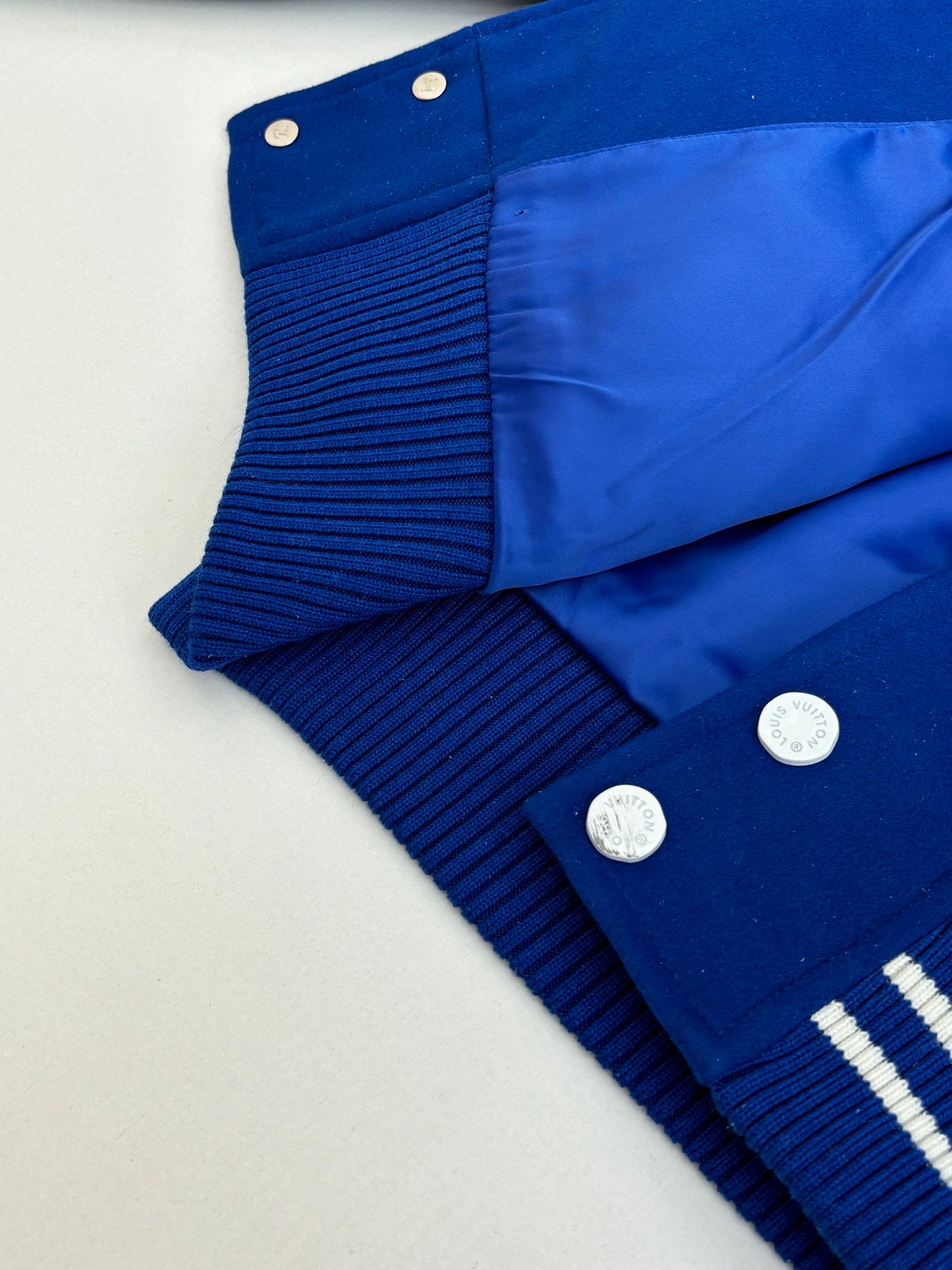Blue varsity jacket back with ribbed cuff details and snap buttons
