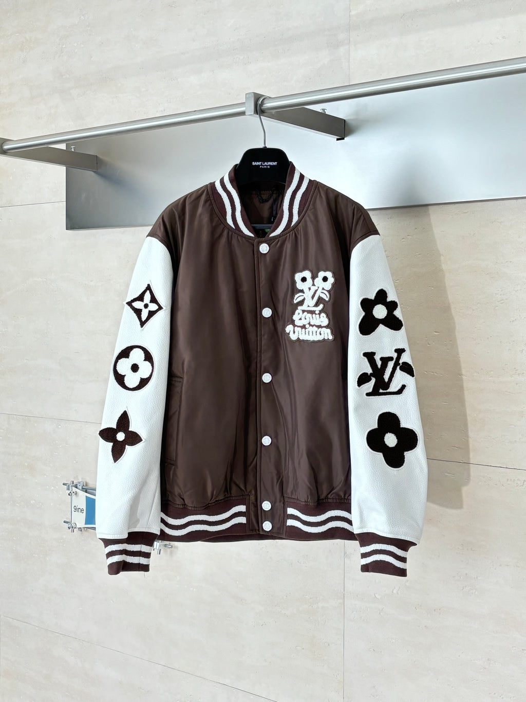 Louis Vuitton brown long jacket with white sleeves, button front, and large logo patches