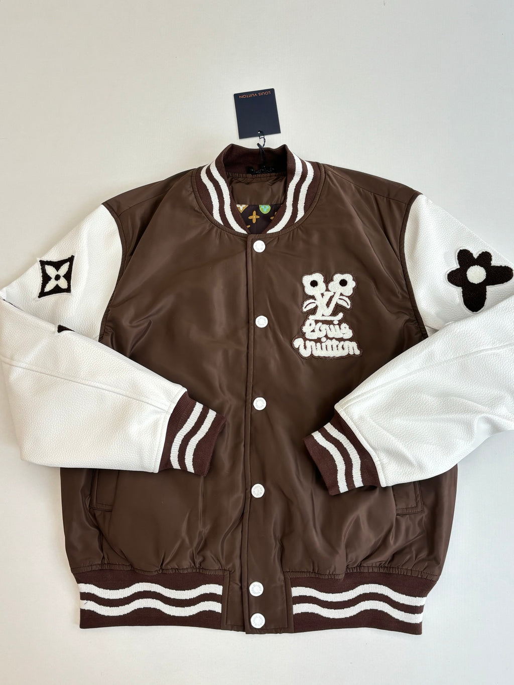Louis Vuitton brown long jacket with white sleeves, striped cuffs, and front logo patch