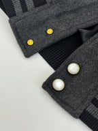 Dark gray wool varsity jacket cuff detail with snap buttons and ribbed stripes