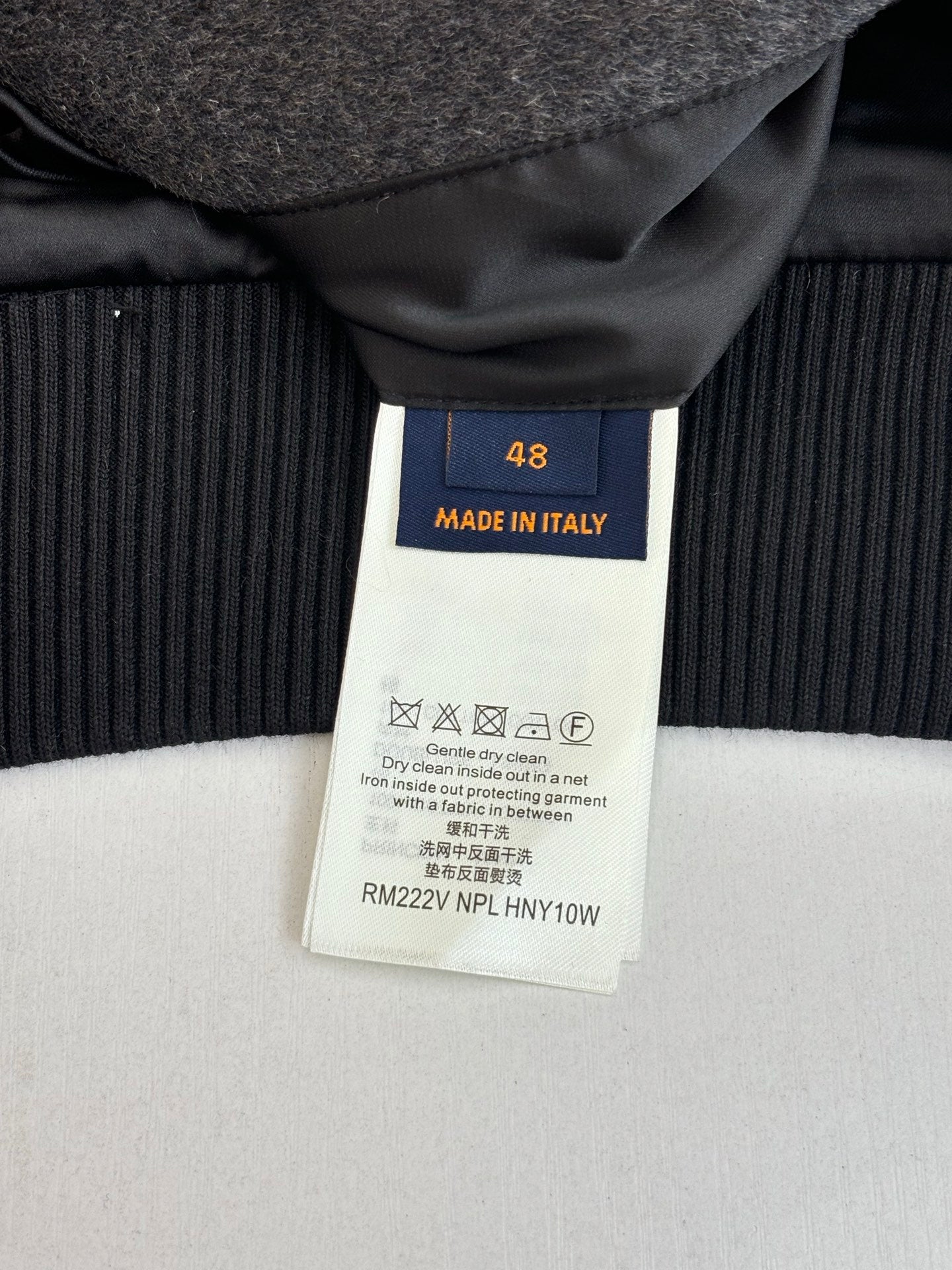 Size 48 "Made in Italy" care label on dark ribbed cuff of varsity jacket