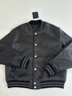 Dark gray varsity jacket with button placket and striped ribbed cuffs