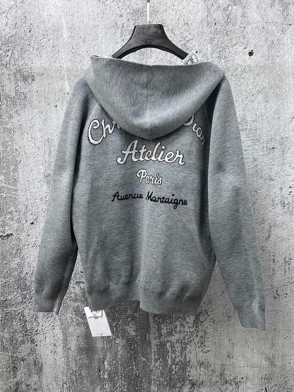 Gray zip-up hoodie with printed “Atelier Paris” text on back