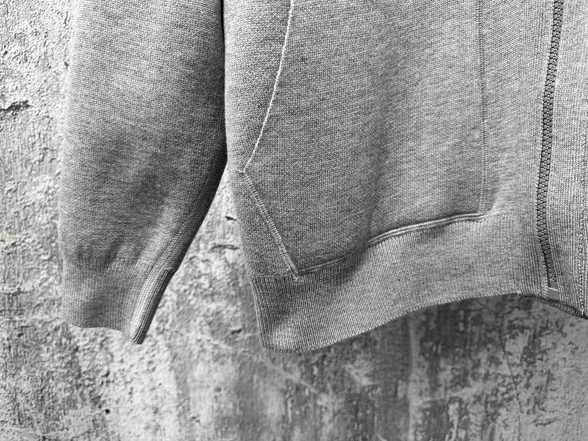 Gray hoodie close-up of zip-front and kangaroo pocket seam