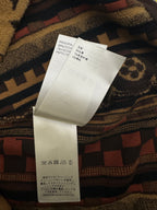 Paper care label on patterned short-sleeve button-up shirt with barcode and material text