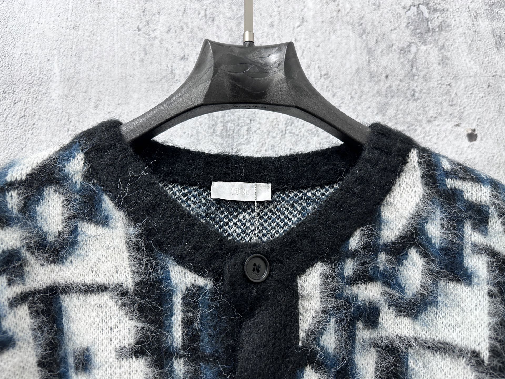 Dior long sweater neckline close-up with black buttons and blue/white pattern