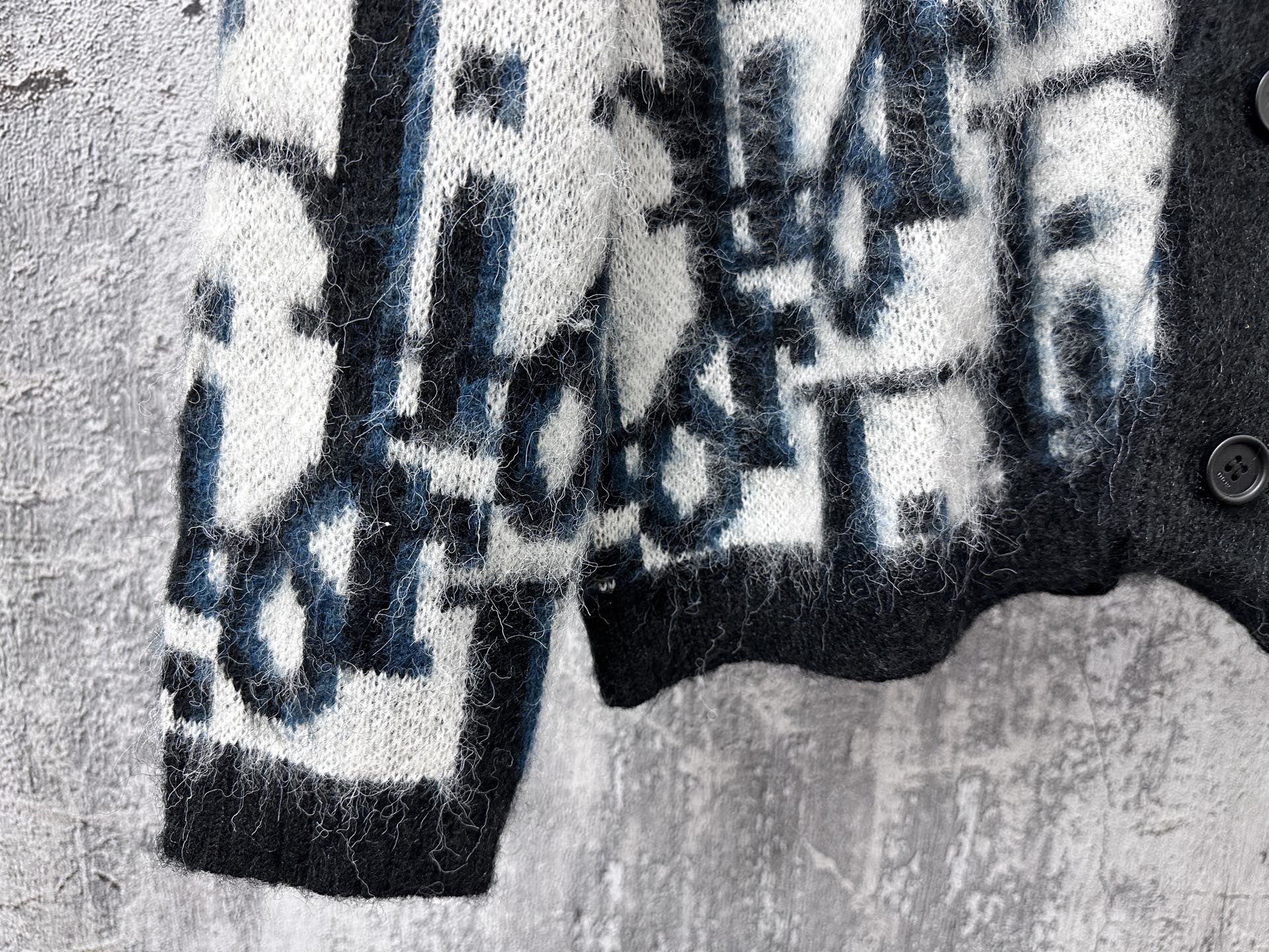 Dior long sweater sleeve with blue and white abstract blocks on dark knit