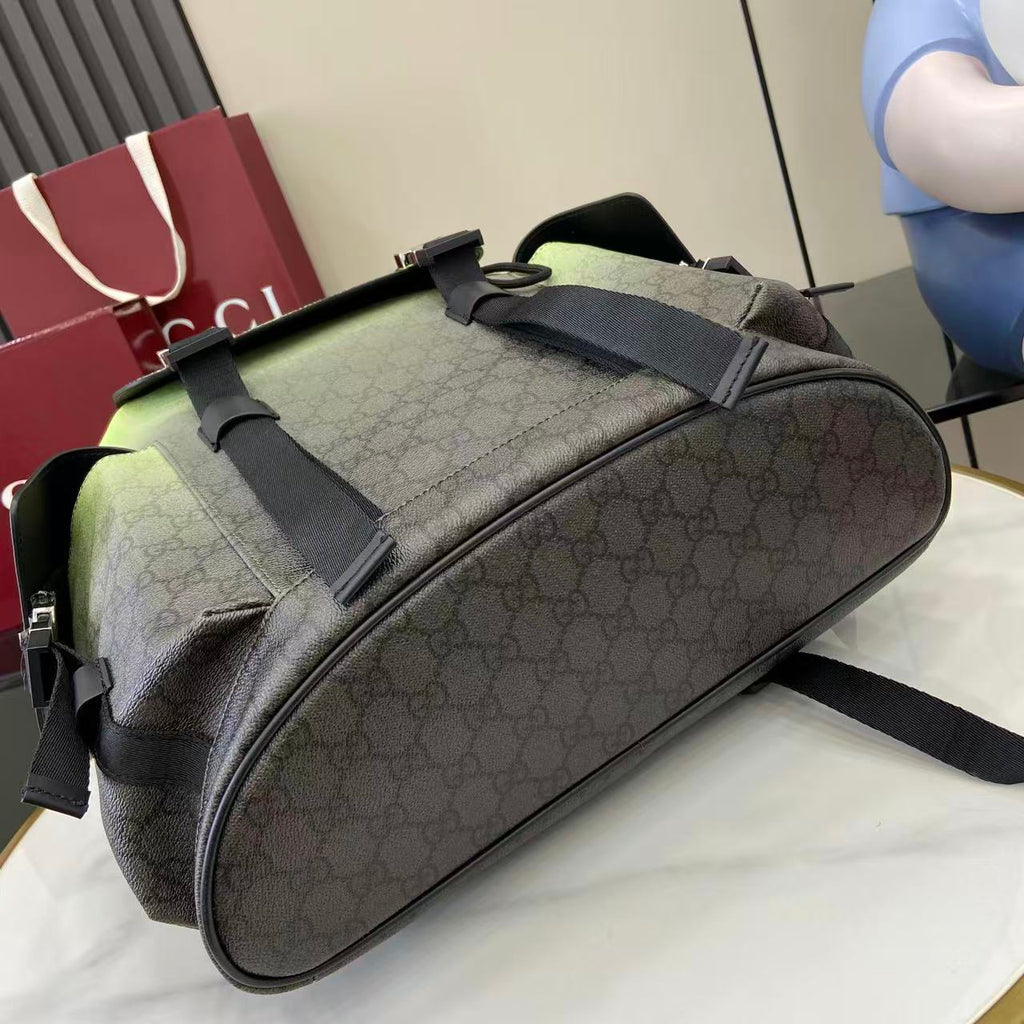Gucci duffel-style bag with dark green monogram canvas, black web straps, and zipper top