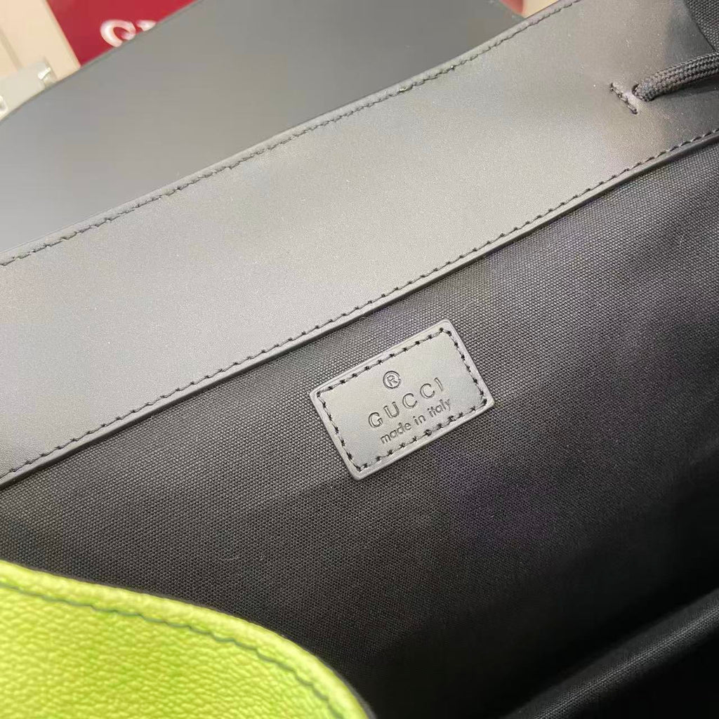 Gucci bag logo patch on dark fabric near a light trim seam