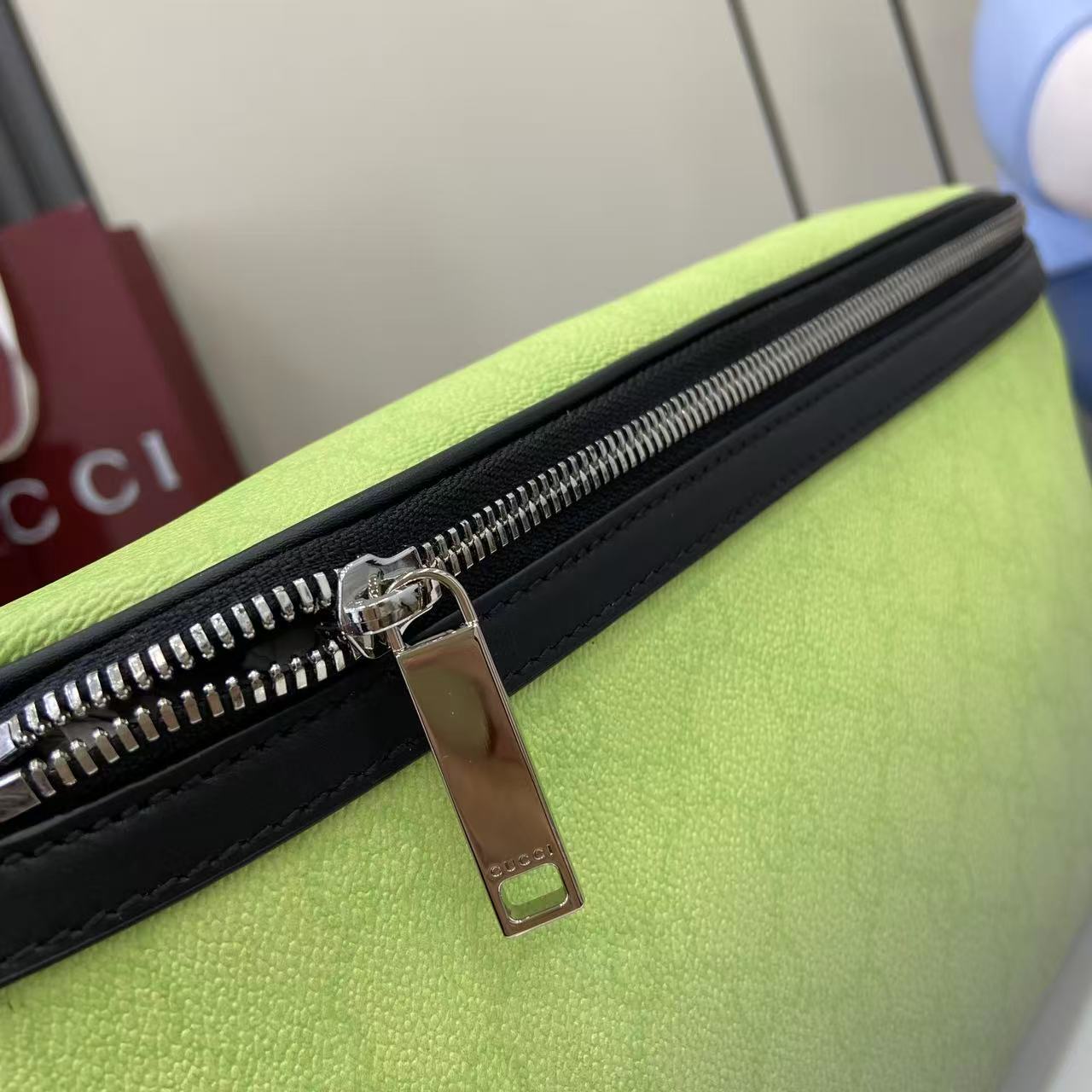 Gucci belt bag zip close-up with black trim and metal pull tab