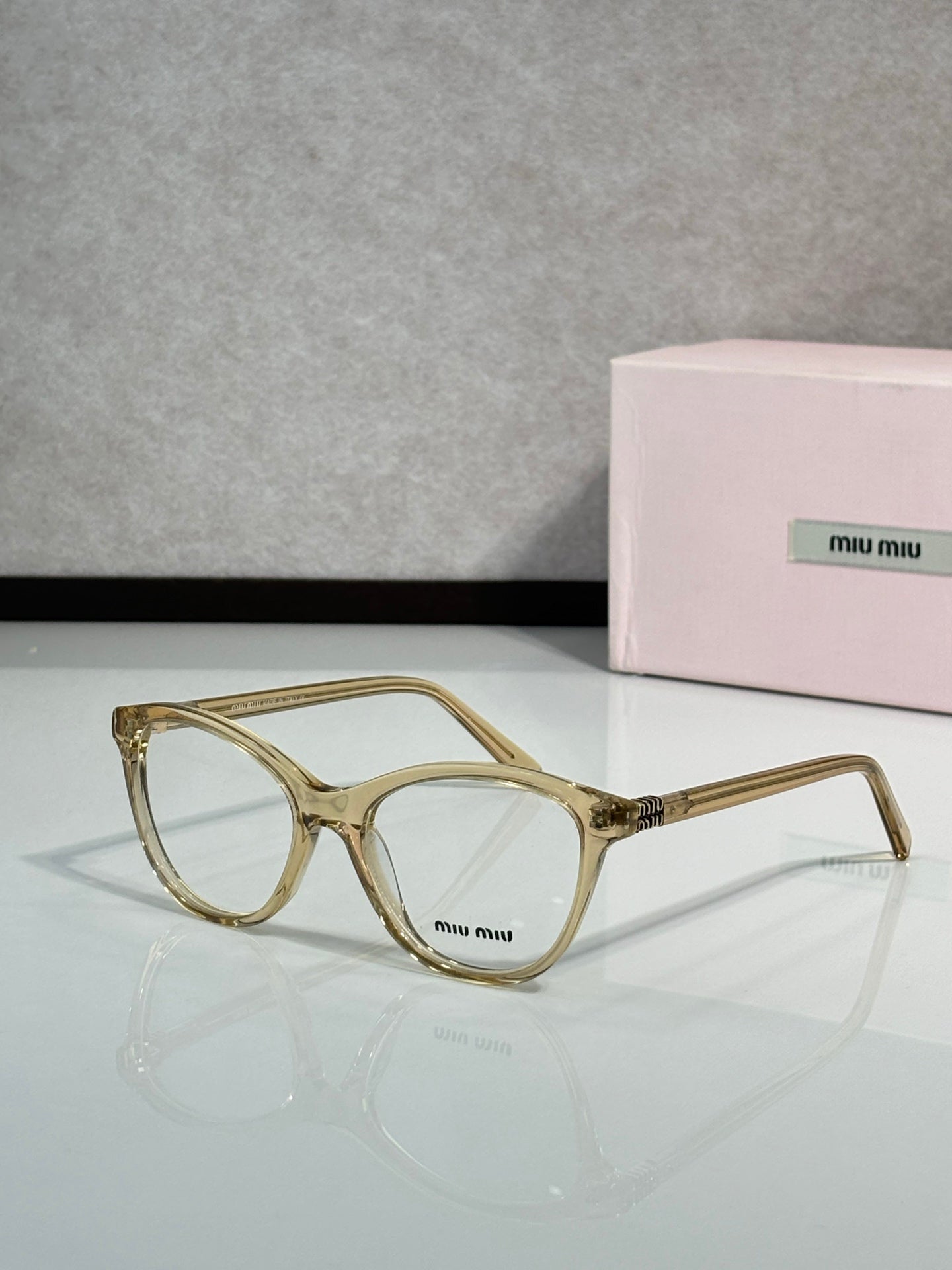 MiuMiu eyeglasses with gold square frames and clear lenses