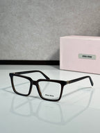 Black rectangular eyeglasses with gold-toned hinge detail