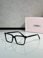 Black rectangular eyeglasses with clear lenses and gold-toned accent