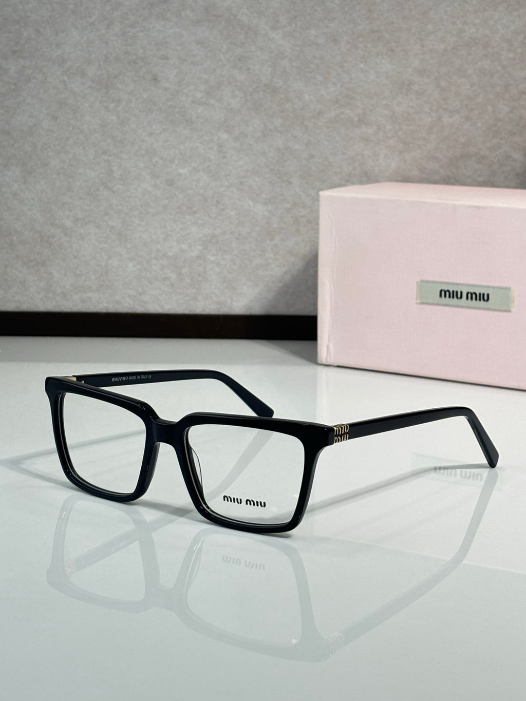 Black rectangular eyeglasses with Miu Miu logo on the front