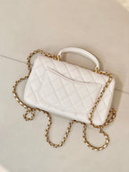Chanel quilted mini flap bag angled view, white with gold chain strap and CC logo