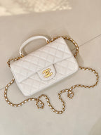 Chanel quilted mini flap bag in white with gold chain strap and CC logo detail