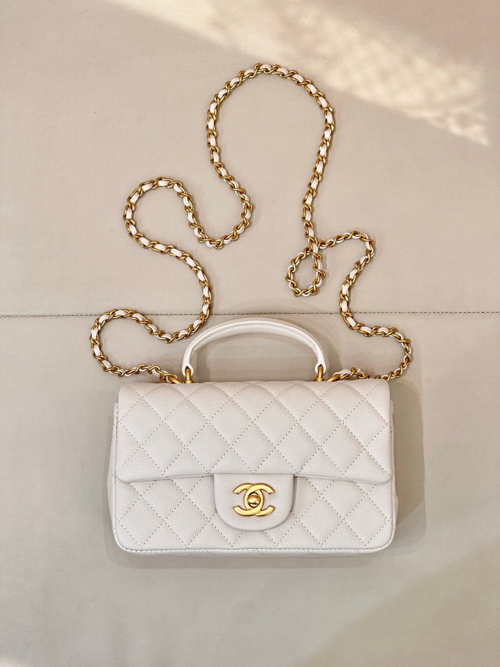 Chanel quilted mini flap bag in white with gold chain strap and CC turn-lock