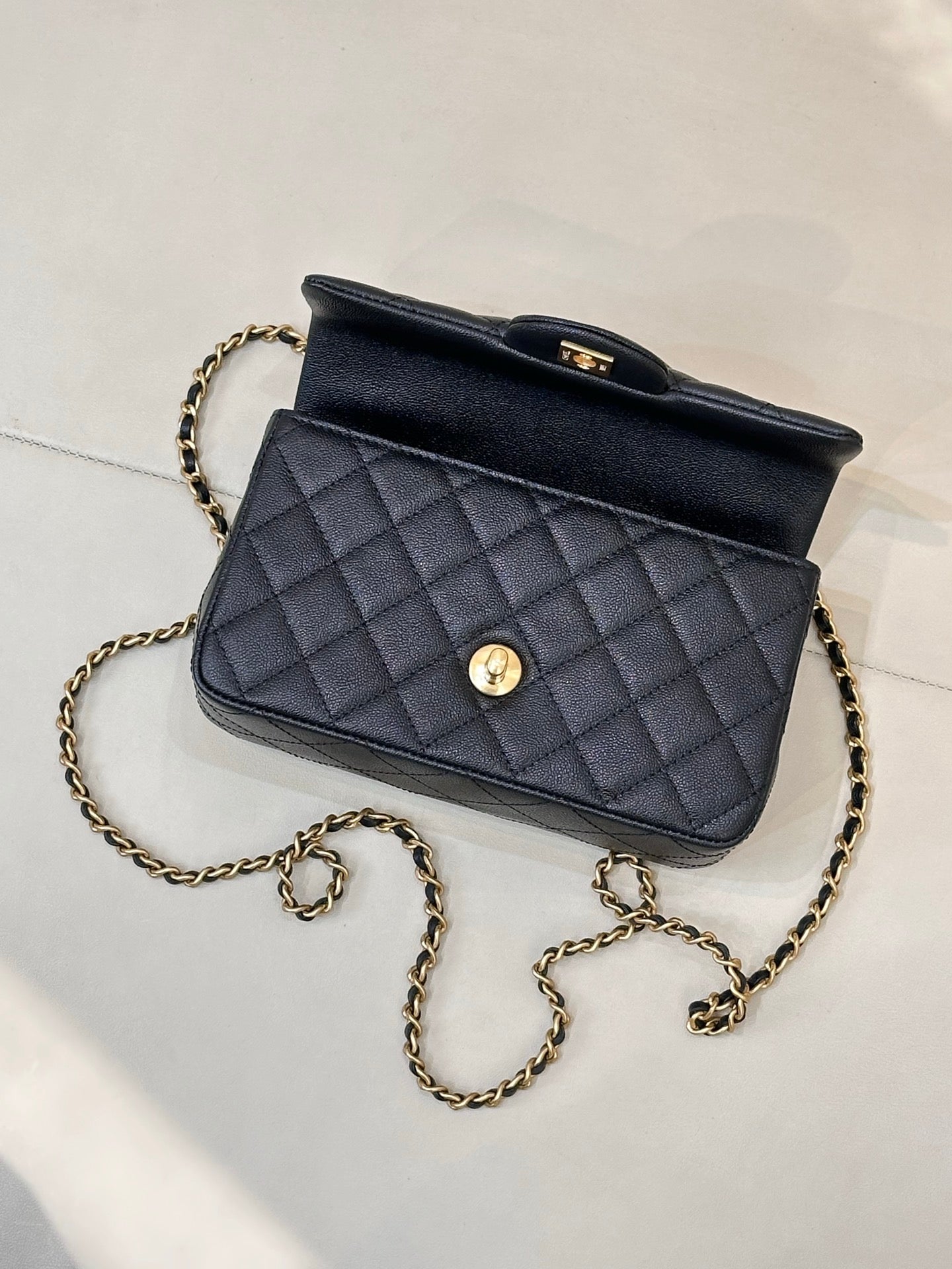 Chanel dark navy quilted mini bag with gold chain strap and front button detail