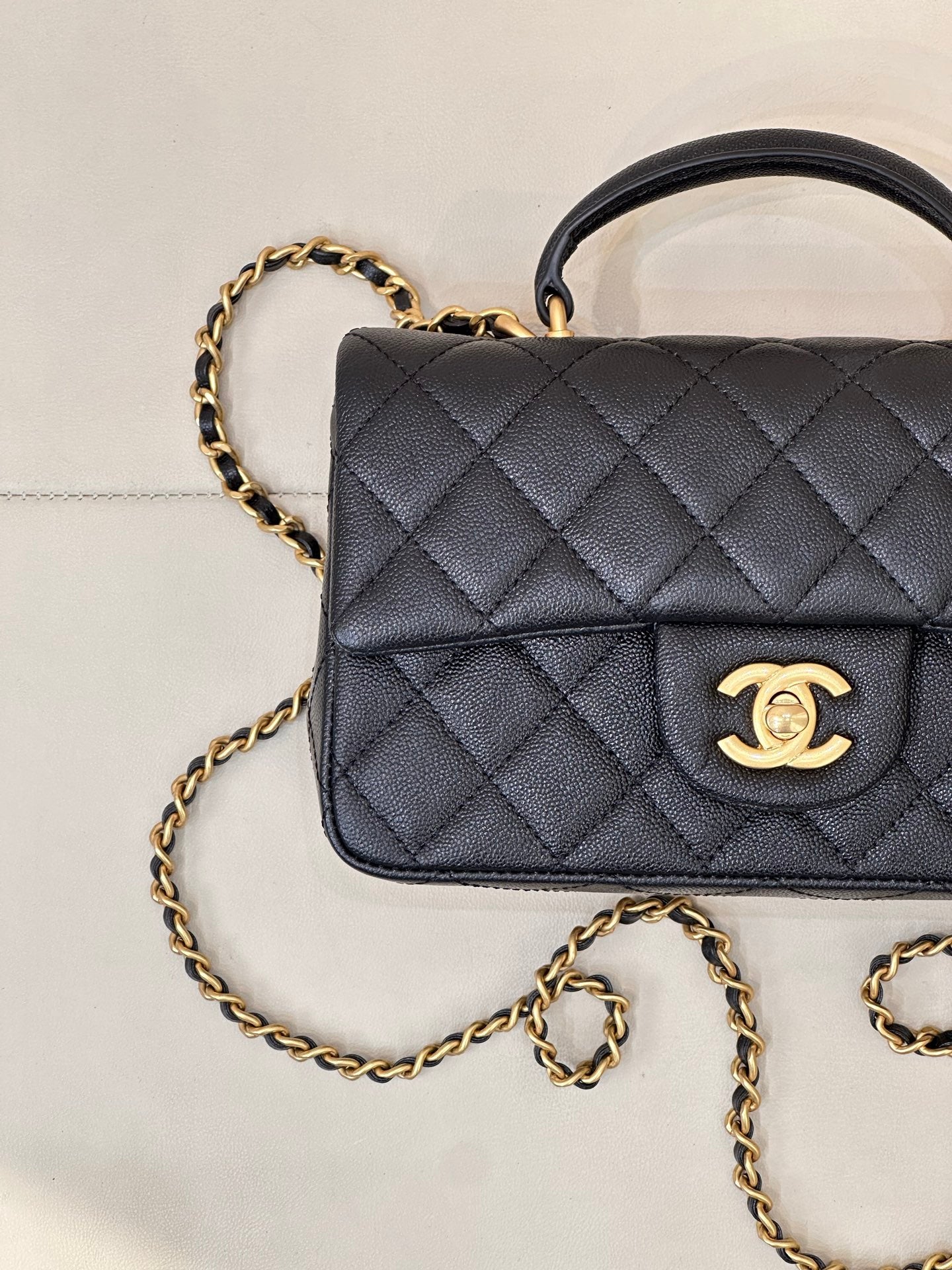 Chanel dark navy quilted flap bag close-up with gold chain strap and logo emblem