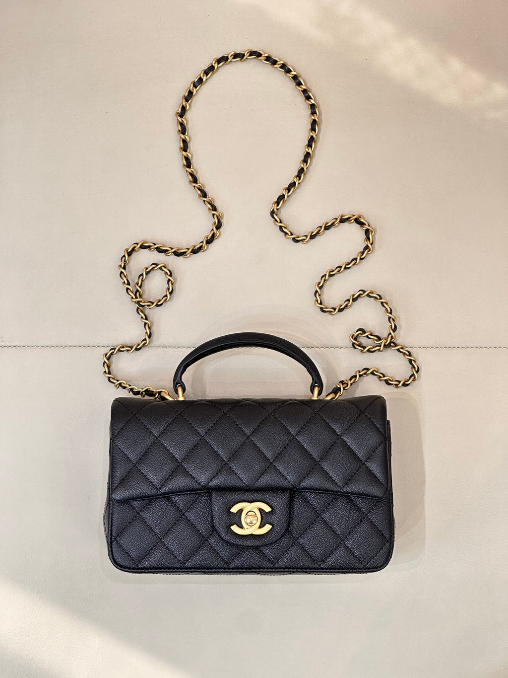 Chanel dark navy quilted flap bag with gold chain strap and top handle, logo clasp