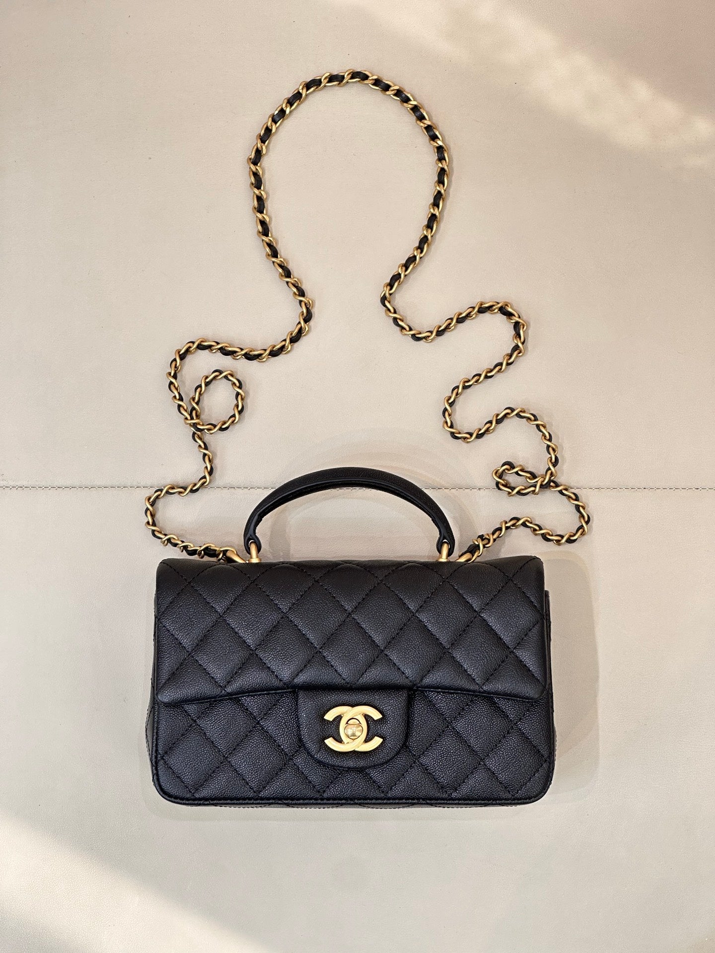 Chanel dark navy quilted flap bag with gold chain strap and top handle, logo clasp