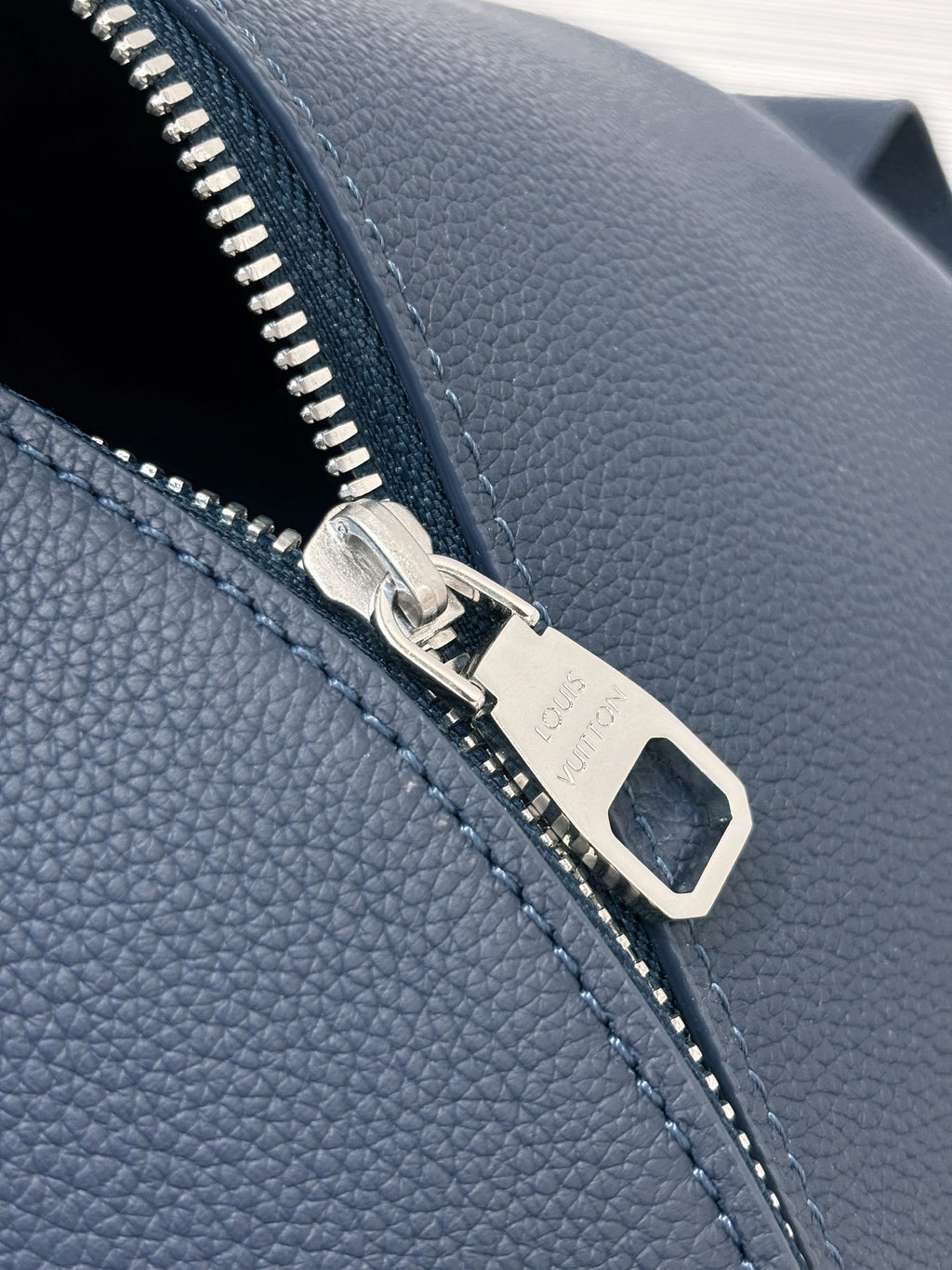 Louis Vuitton blue leather zipper pull detail with silver hardware