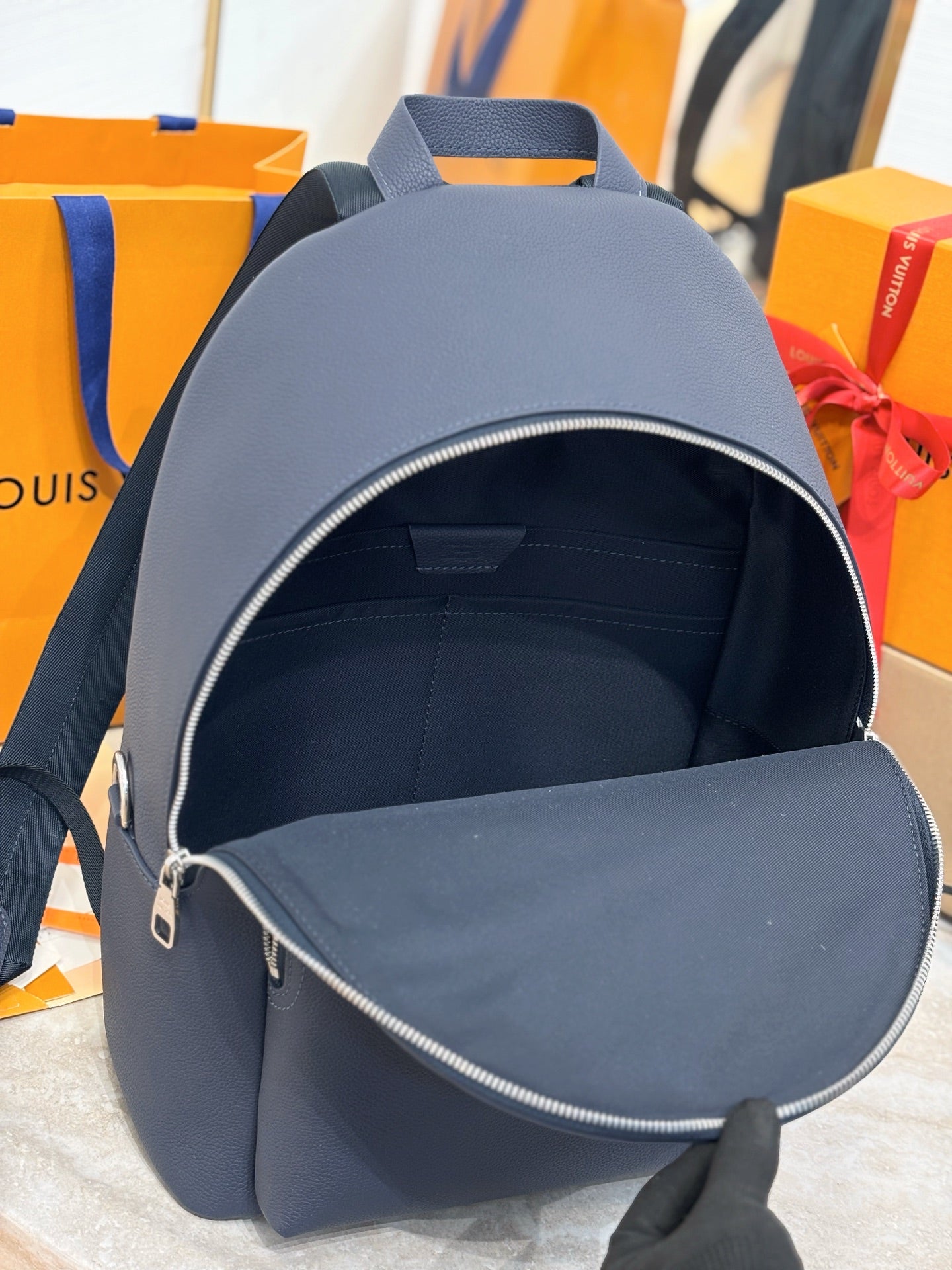Louis Vuitton blue backpack open top with visible zipper and interior