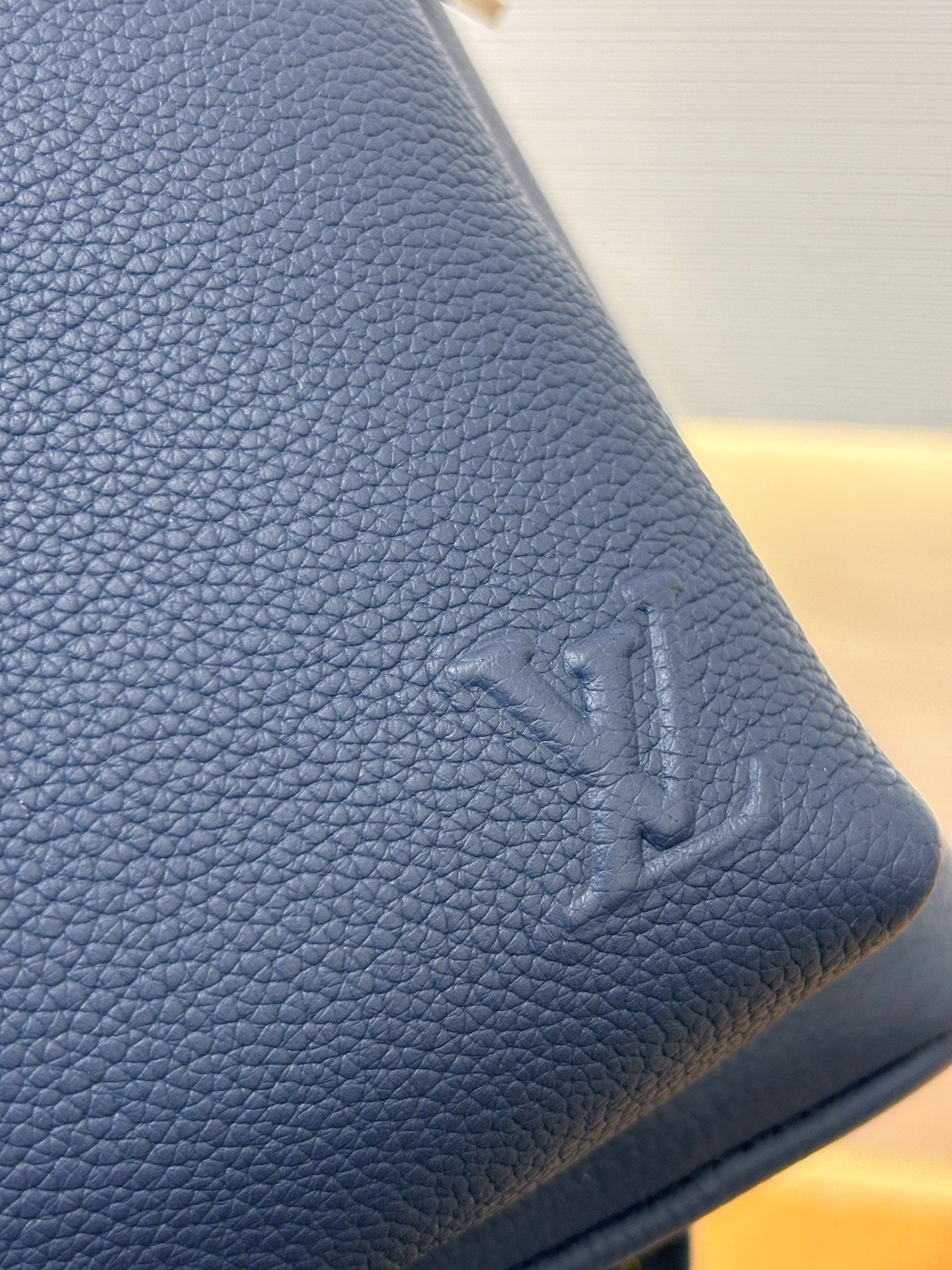 Louis Vuitton blue leather backpack corner with embossed logo
