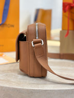 Tan leather Louis Vuitton bag with adjustable strap and side pocket opening