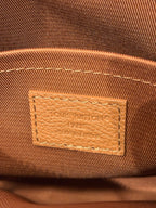 Close-up of Louis Vuitton tan leather bag logo patch with stitched edges