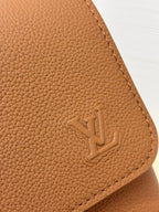 Close-up of tan pebbled leather Louis Vuitton logo on side panel