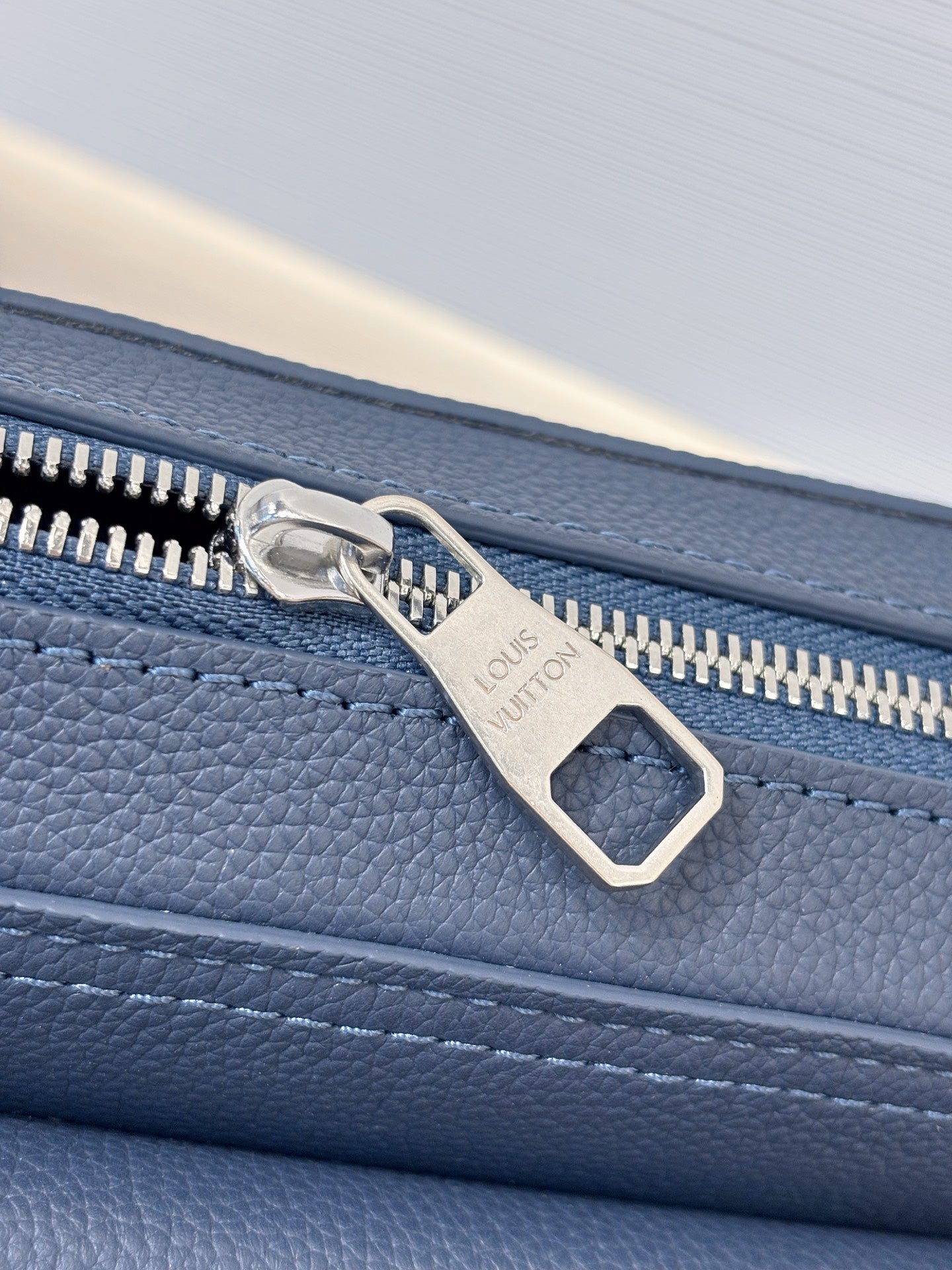 Louis Vuitton blue leather bag zipper pull with embossed logo on trim
