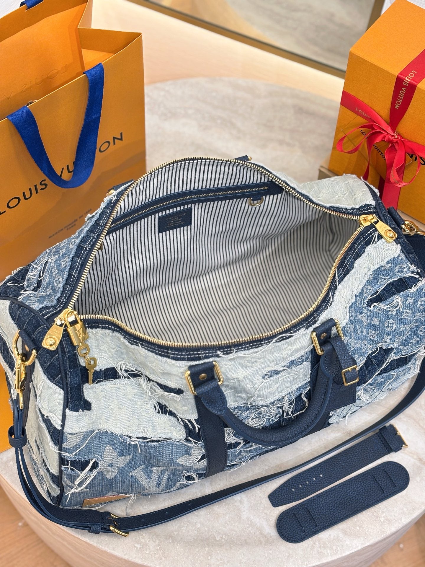Louis Vuitton patchwork denim handbag open view with striped interior lining and zipper